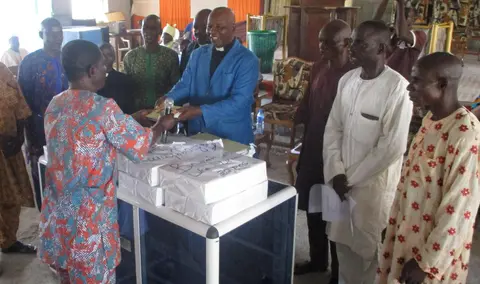 Handing over reading and writing materials to the church